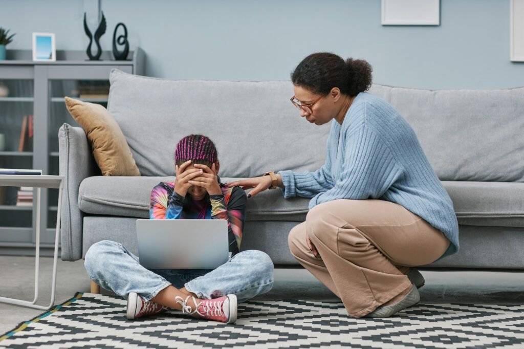 Depressed teenage girl sitting on floor with mother