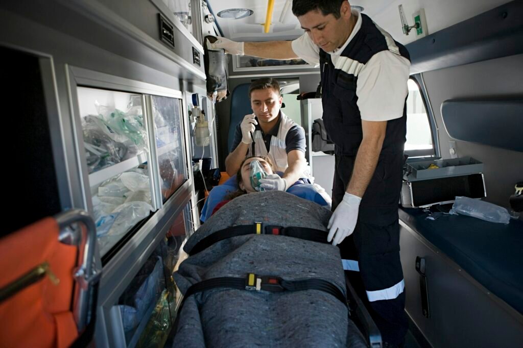 Emergency responders tending to a patient in an ambulance.