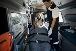 Emergency responders tending to a patient in an ambulance.