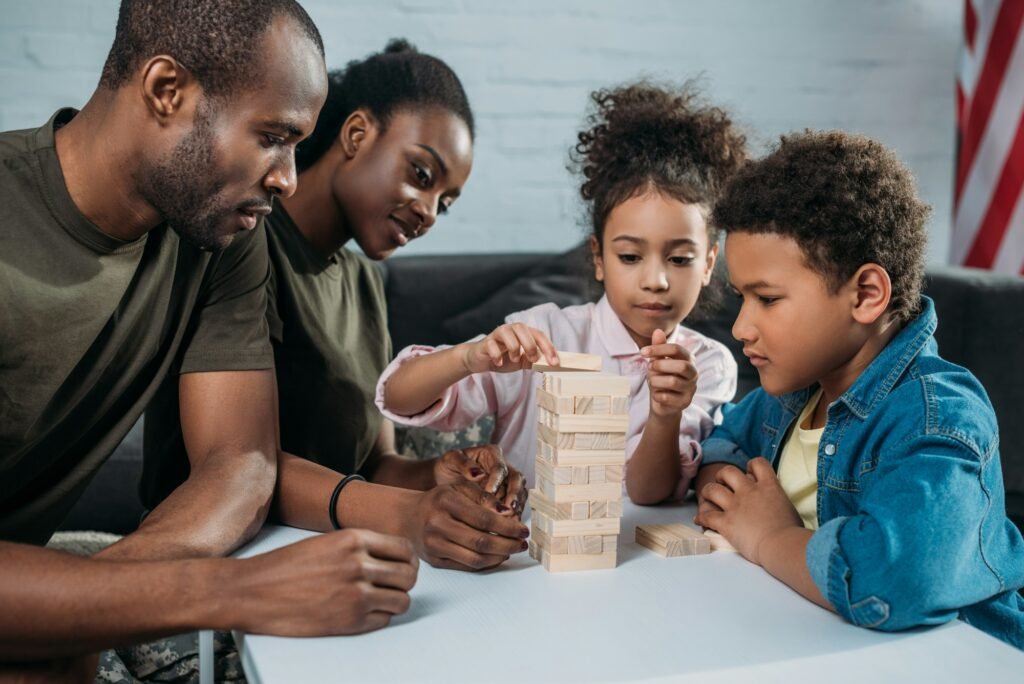 Parents in camouflage clothes with their children playing wooden blocks game